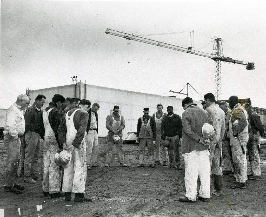Workers pray at the Oakland California Temple construction site. 