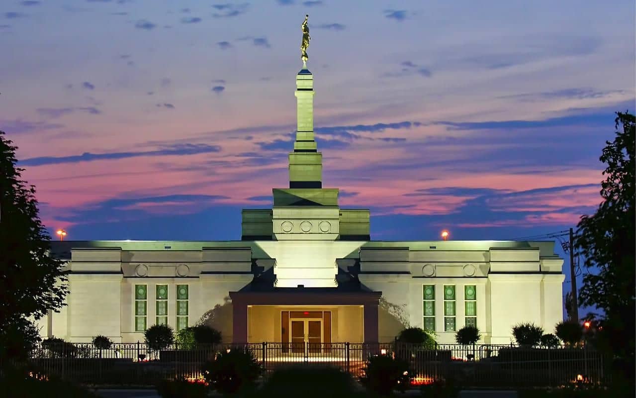 The Montreal Quebec Temple, a white building with with brown doors.