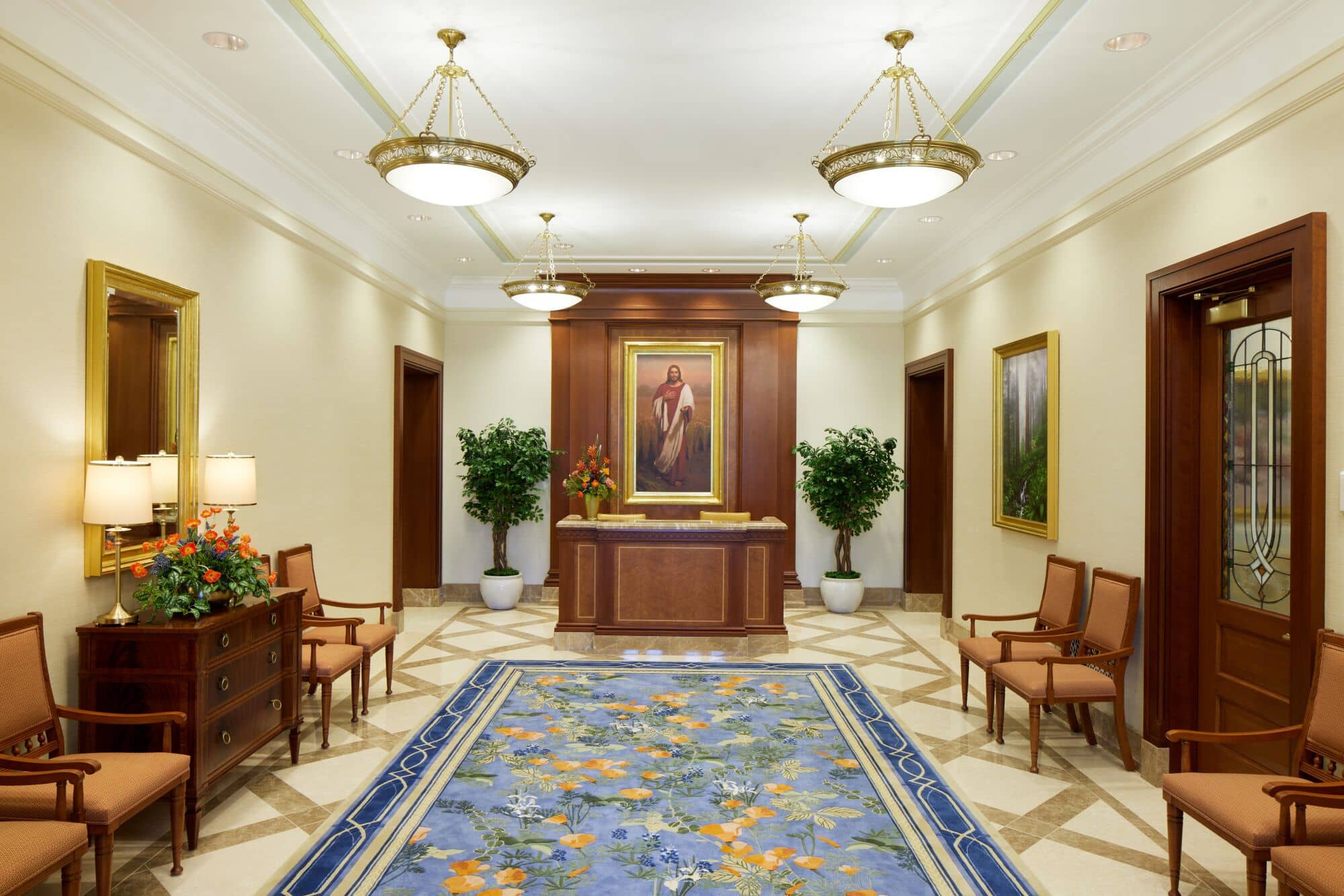 A blue rug on the floor and a front desk in the Feather River temple, with a painting of the Savior behind the desk.