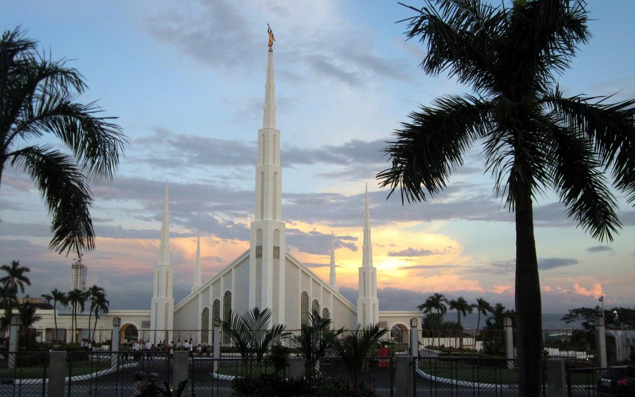 The Manila Philippines Temple, a white building with two large central spires at the front and back with four smaller spires at their sides.