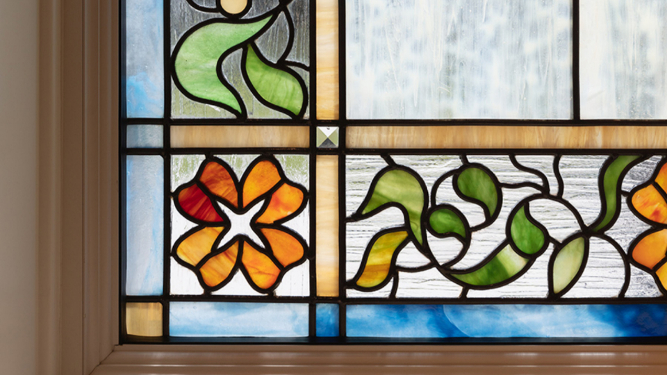 A close-up of a stained-glass window with floral designs.