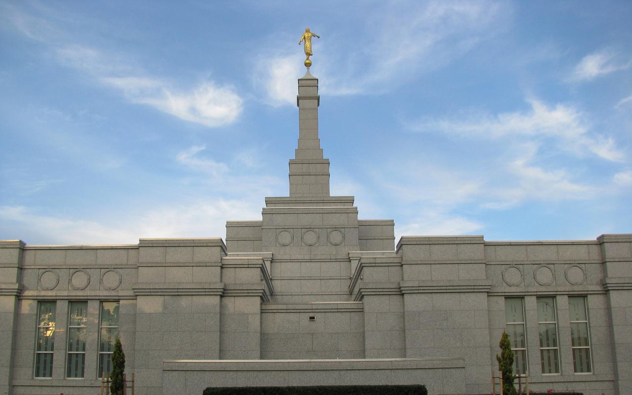 The Adelaide Australia Temple, a white building with a spire topped by a golden statue of an angel blowing a trumpet.