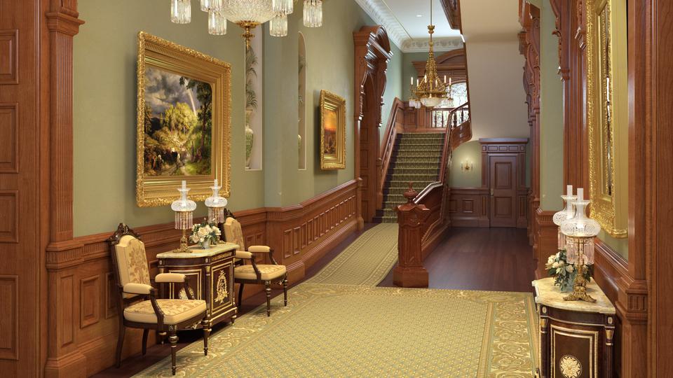 A hallway with paintings, a staircase, two chandeliers and two chairs in the background.
