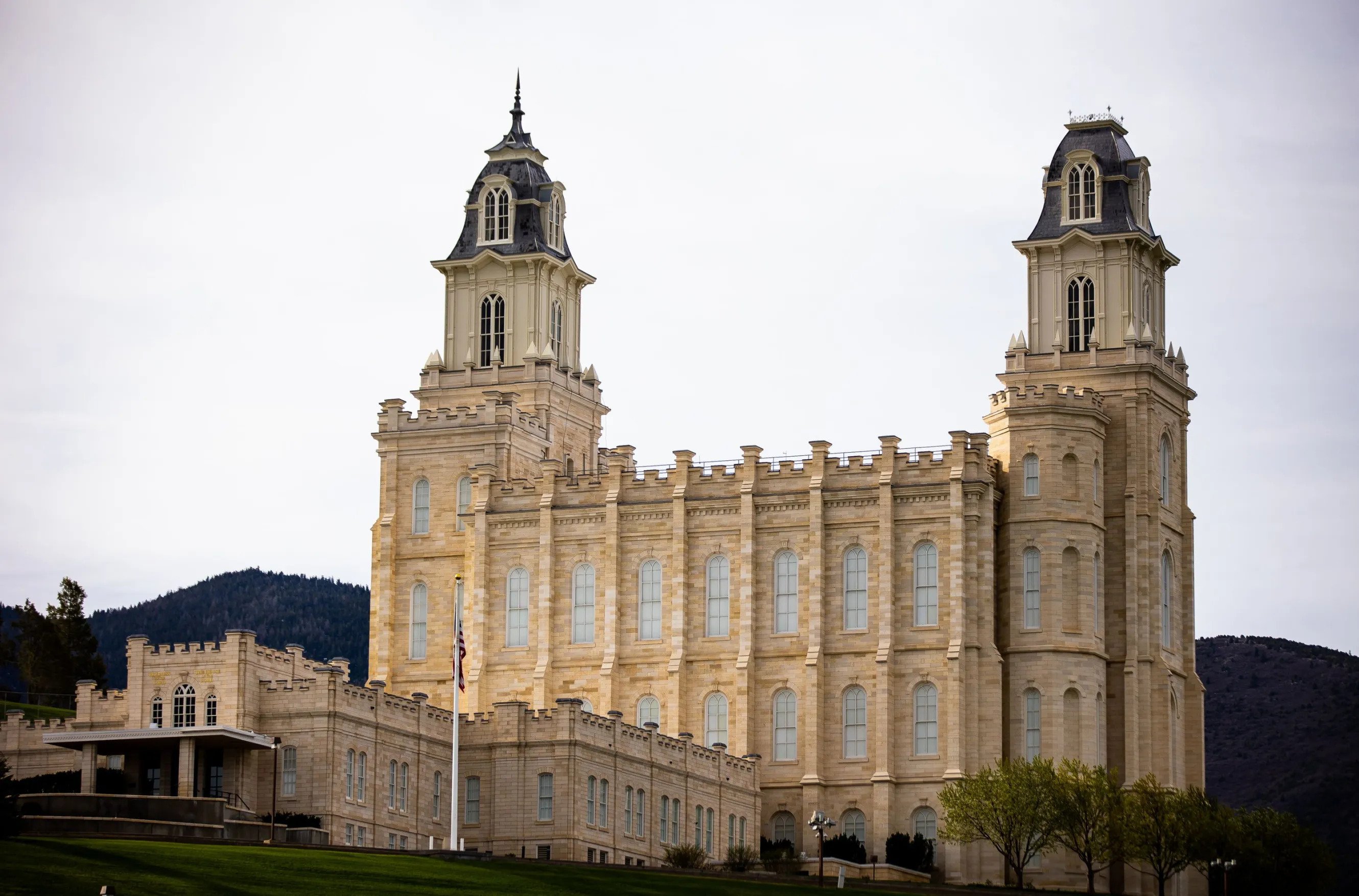 The Manti Utah Temple, a white, rectangular building with two domed towers on both short sides.
