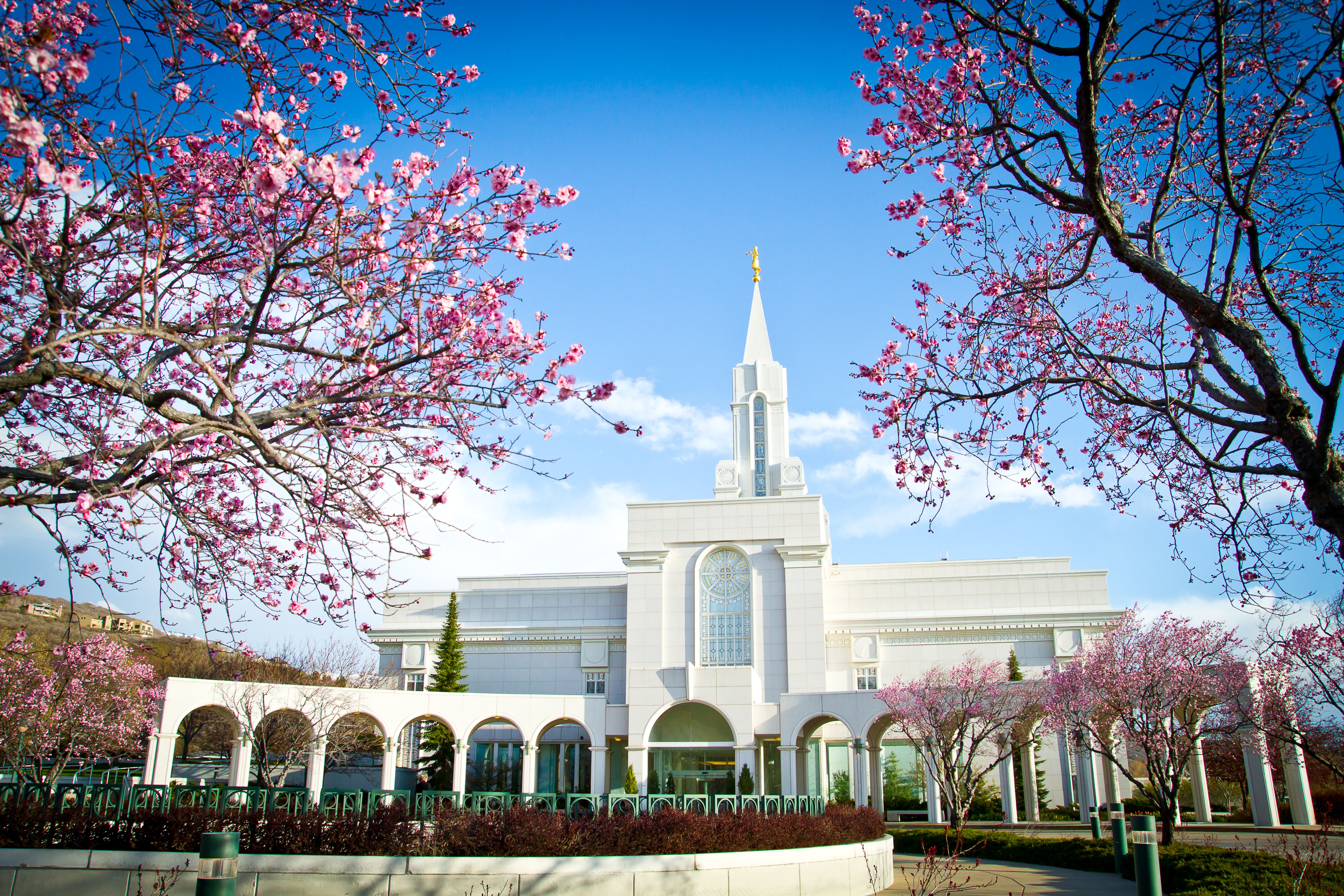 The exterior of the Bountiful Utah Temple, A white building with sections of various heights and a multilevel tower in the center.