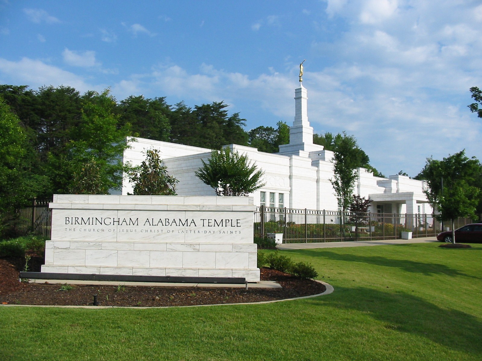The Birmingham Alabama Temple, a white building with a steeple topped by a golden statue of an angel blowing a trumpet.