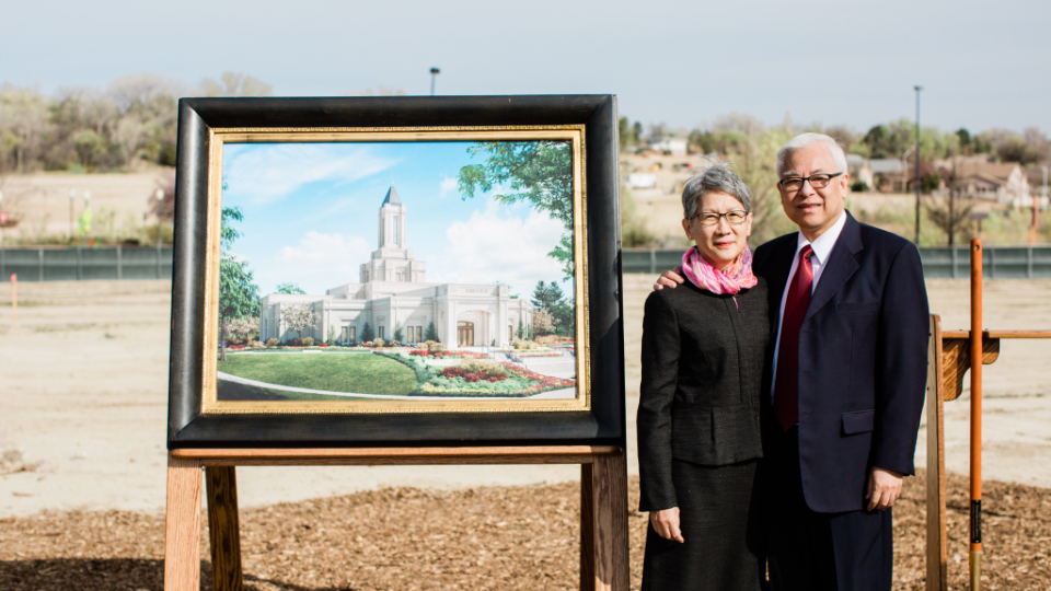 Elder Chi Hong (Sam) Wong, a local regional leader, stands with his wife next to an artistic rendering of the Grand Junction Colorado Temple.