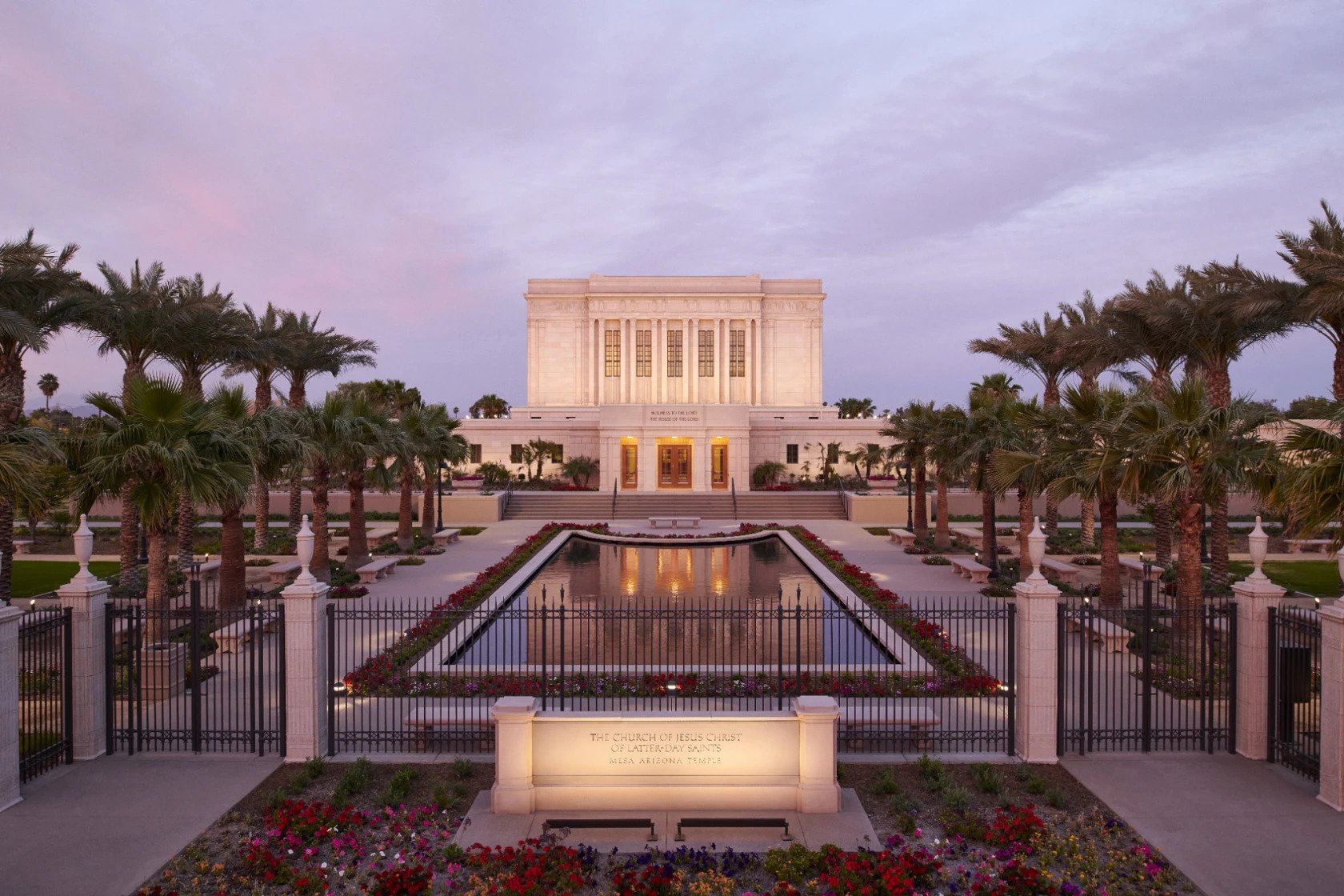 The Mesa temple, a rectangular building with a large reflecting pool in front of it and a stone sign that says "Mesa Arizona Temple."