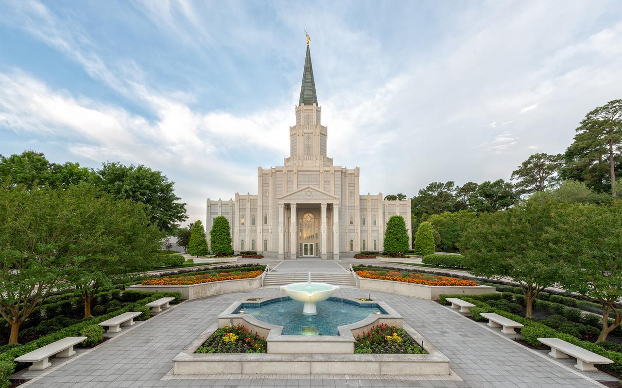 The Houston Texas Temple, a white building with a central tower topped by a golden statue of an angel blowing a trumpet.