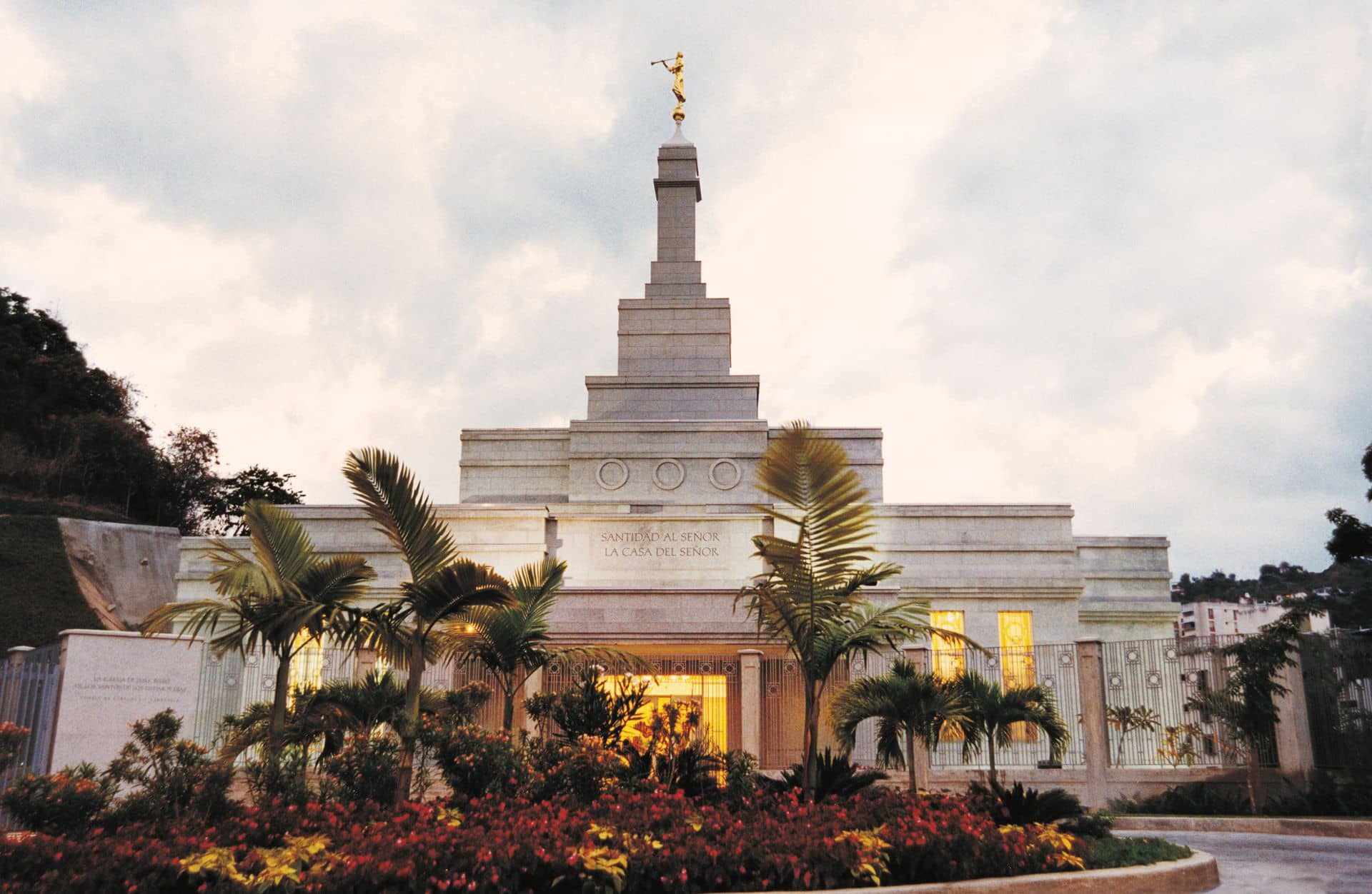 The Caracas Venezuela Temple, a white building with a steeple topped by a golden statue of an angel blowing a trumpet.