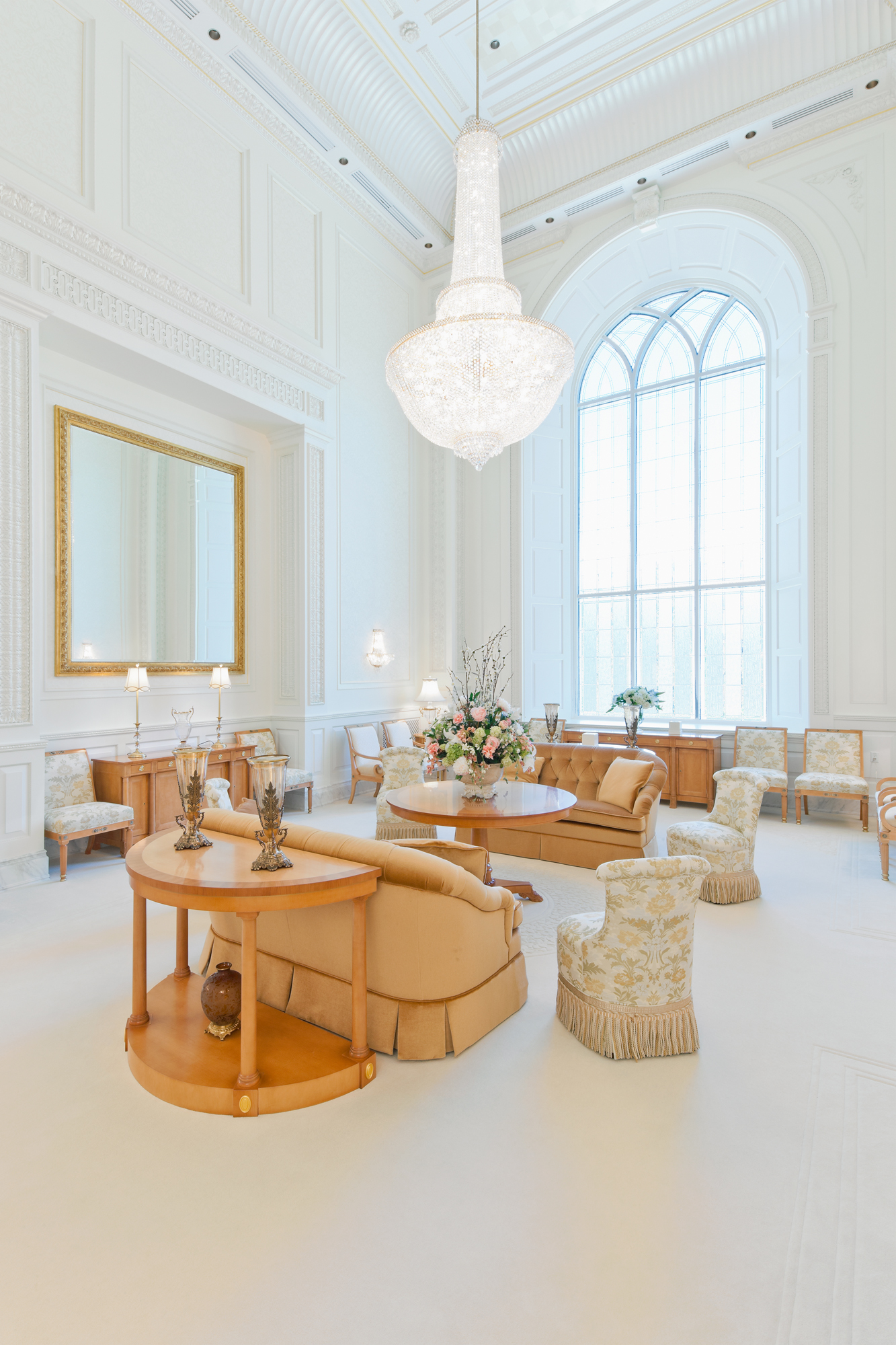 A white room with a large chandelier hanging from the ceiling.