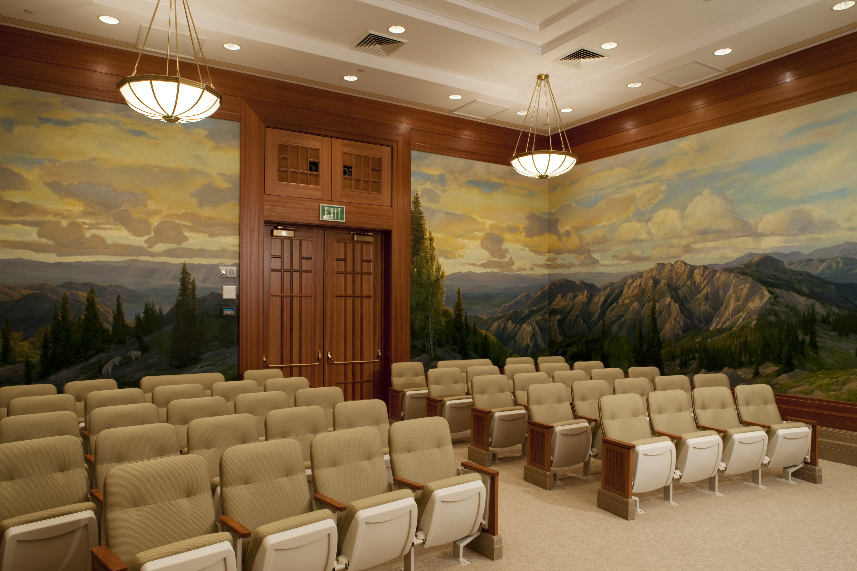 A room full of gray seats, with a mural of mountains along the walls.