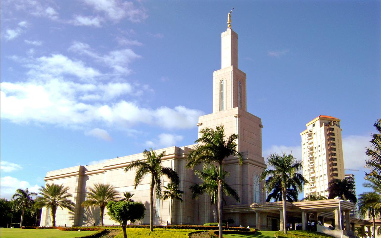 The Santo Domingo Dominican Republic Temple, a white building with spire topped by a statue of a golden angel blowing a trumpet.