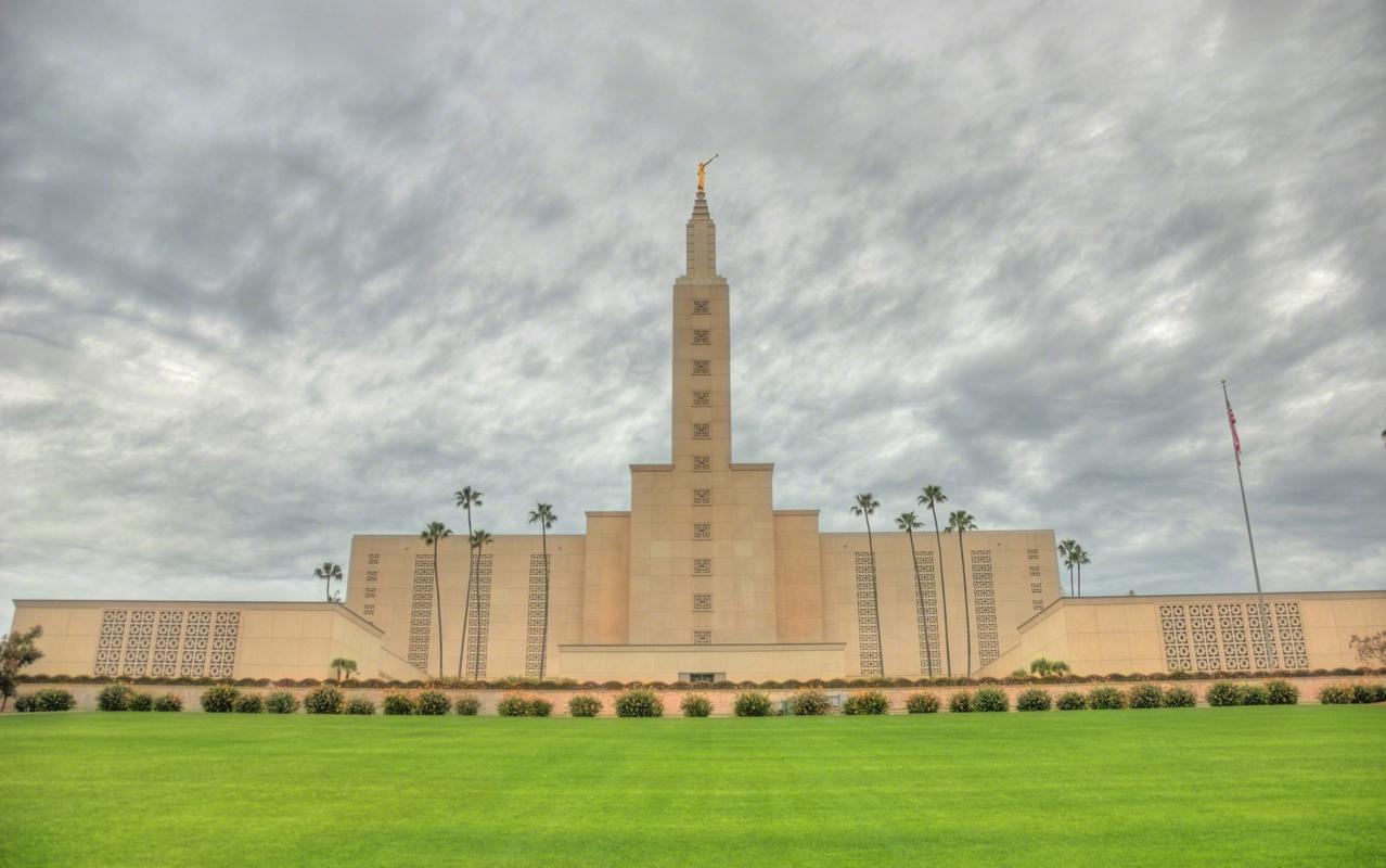 The Los Angeles California Temple, a white building with a spire topped by a golden statue of an angel blowing a trumpet.