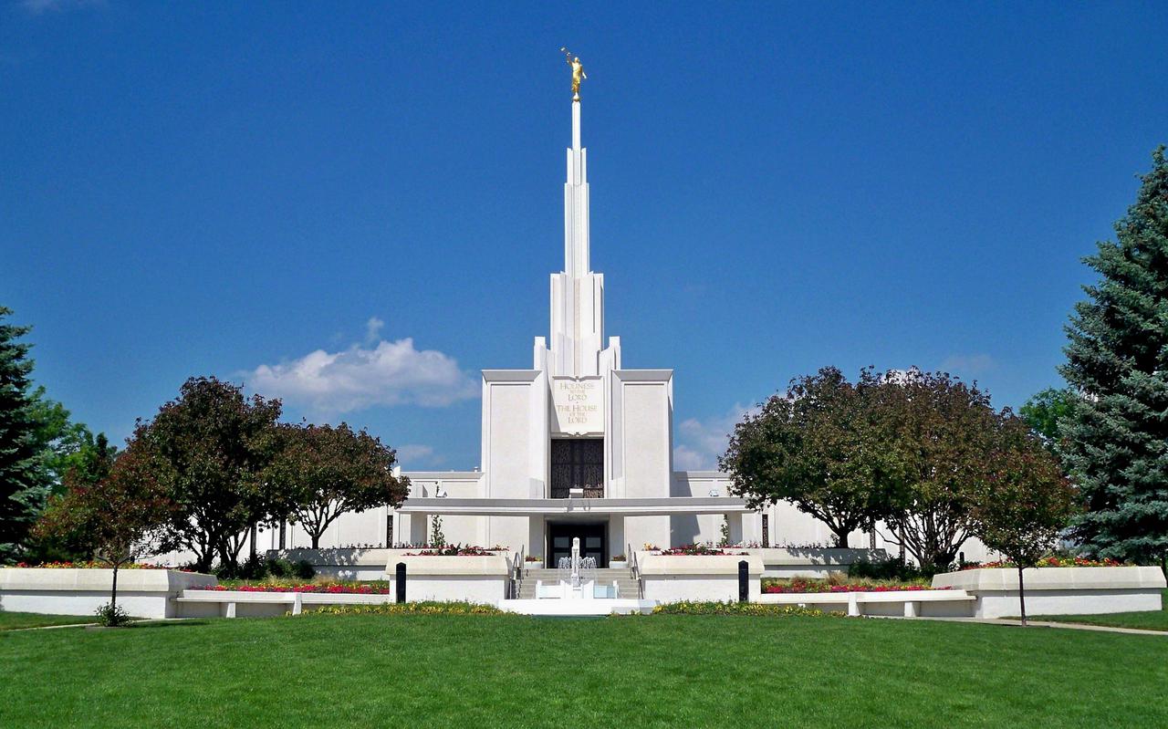 The exterior of the Denver Colorado Temple, a rectangular building with a spire near the front.