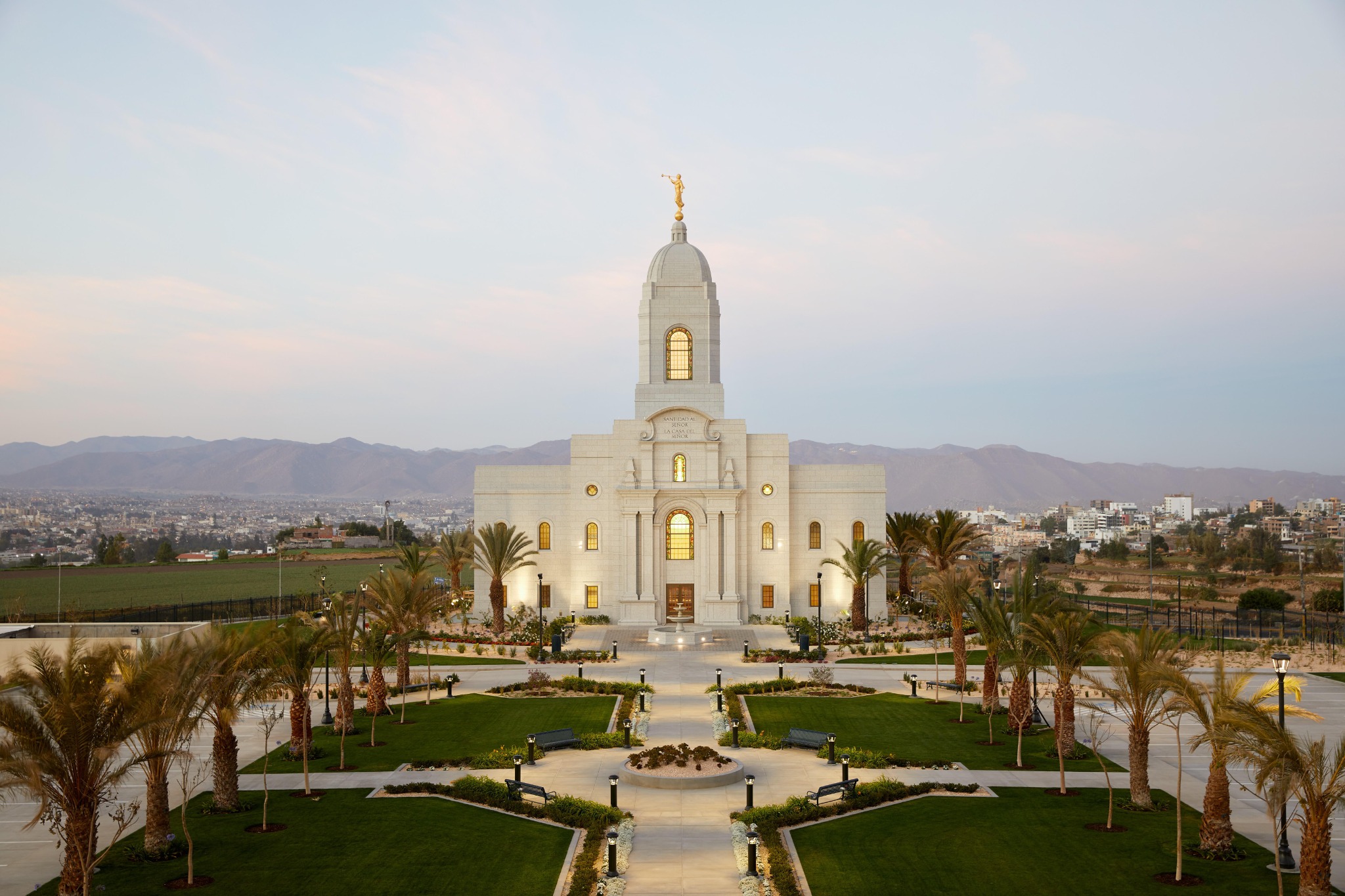 The exterior of the Arequipa Peru Temple, a white, rectangular building with arched windows and a center domed spire.