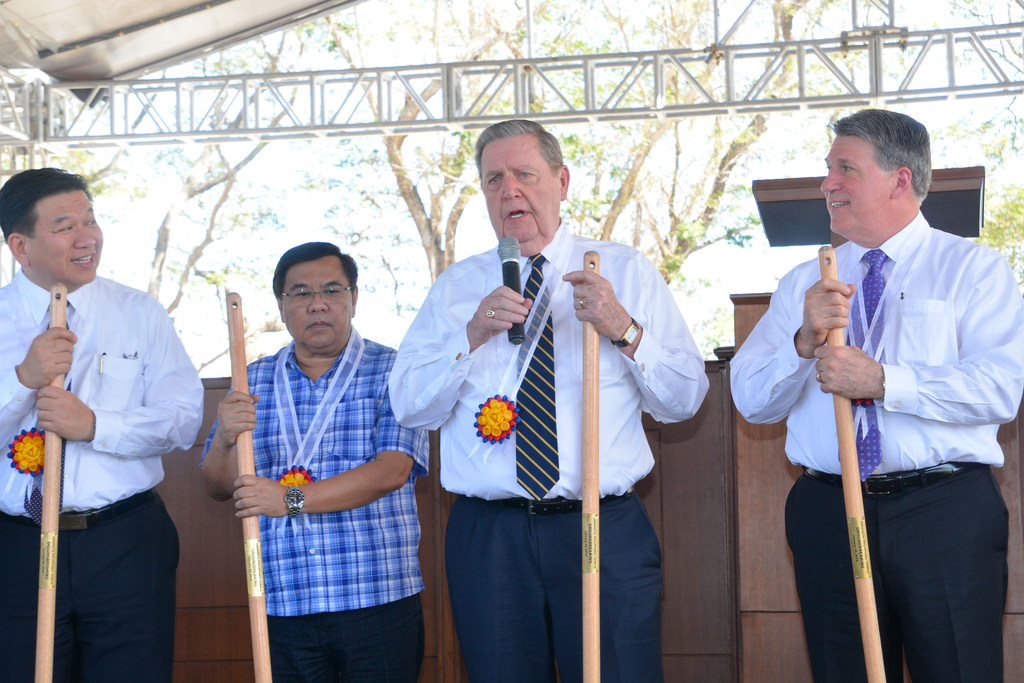Elder Holland holding a shovel with local leaders at the Urdaneta Philippines Temple groundbreaking.