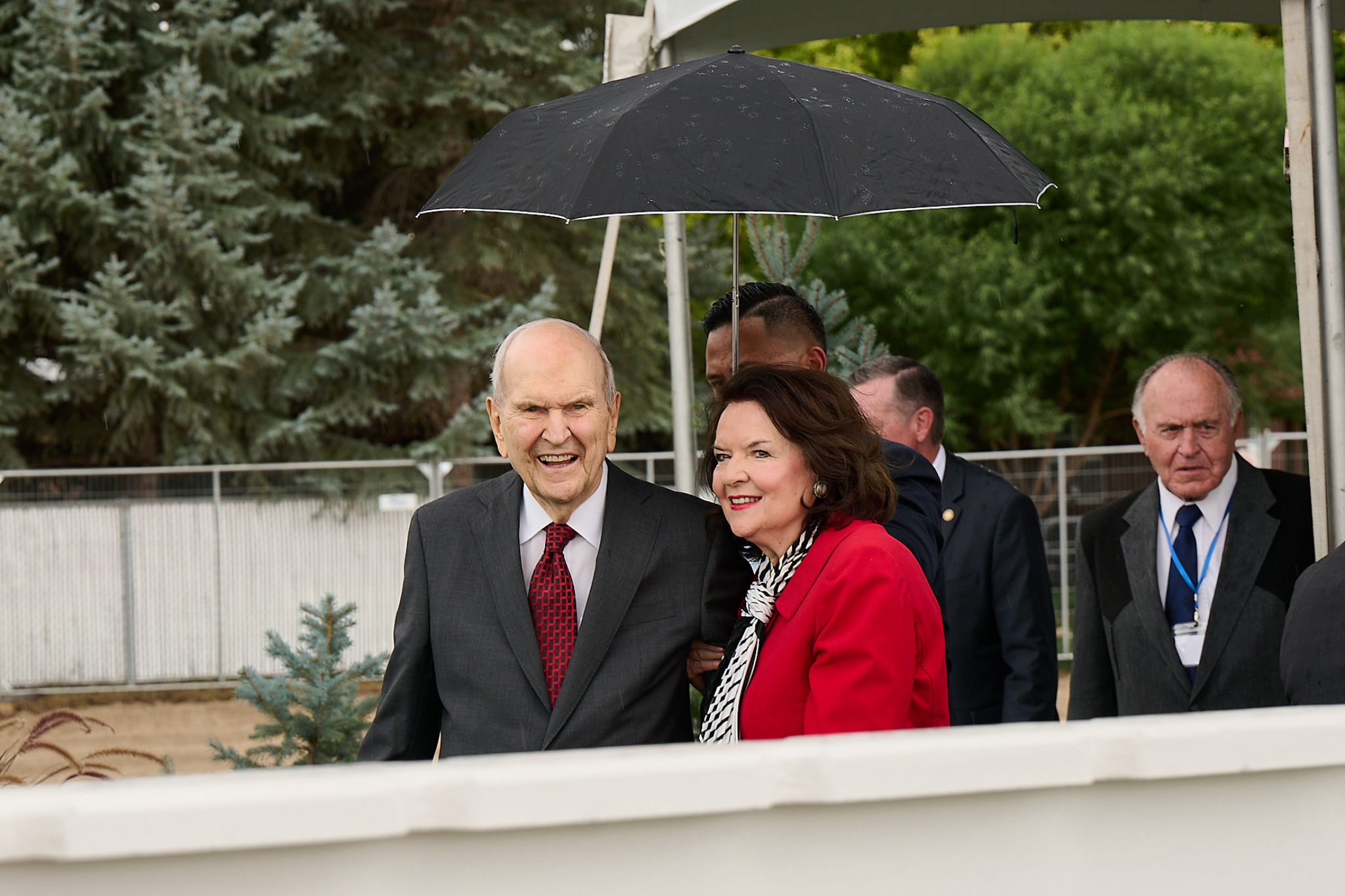 President and Sister Nelson standing together under an umbrella and smiling.