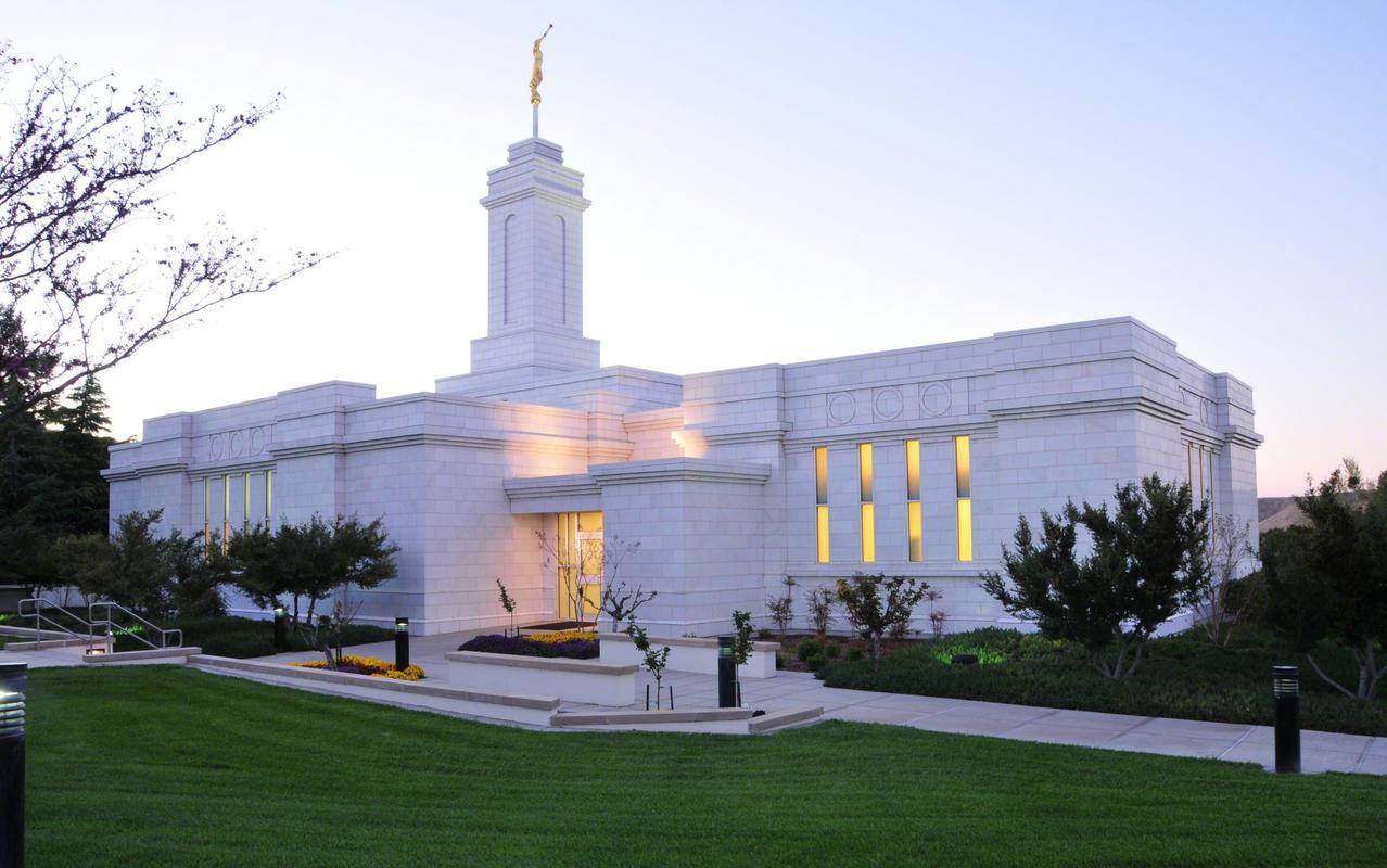 The exterior of the The Colonia Juárez Chihuahua Mexico Temple, a white, one-story building with a center spire.