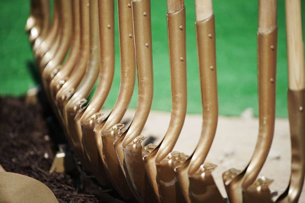A close-up of a row of ceremonial golden shovels.