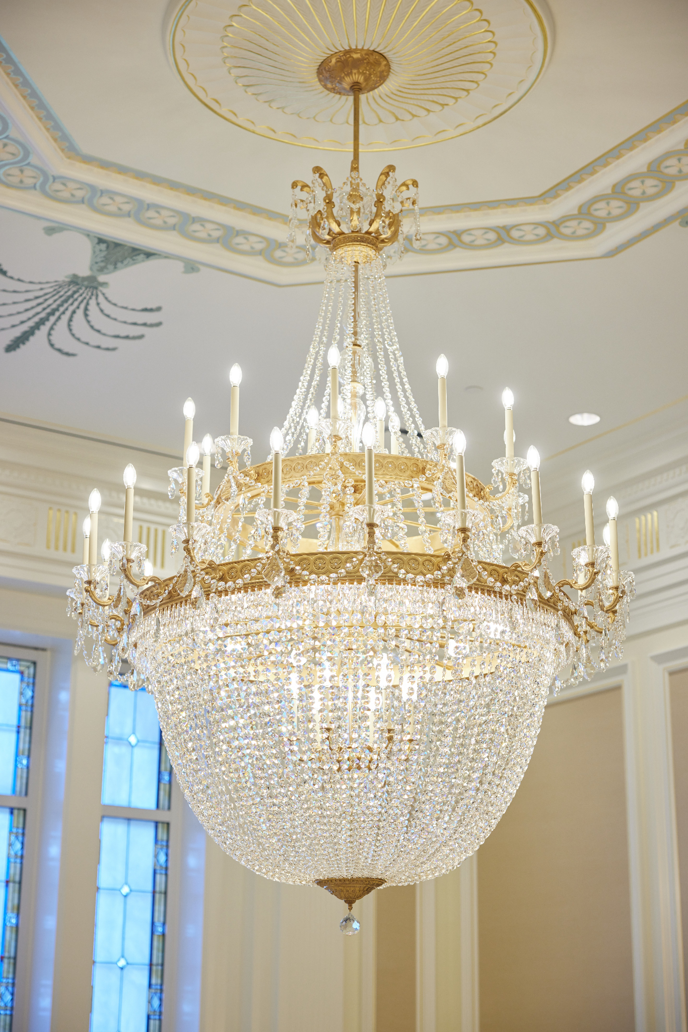 A large chandelier with many pieces of glass throughout and small lightbulbs around the top.