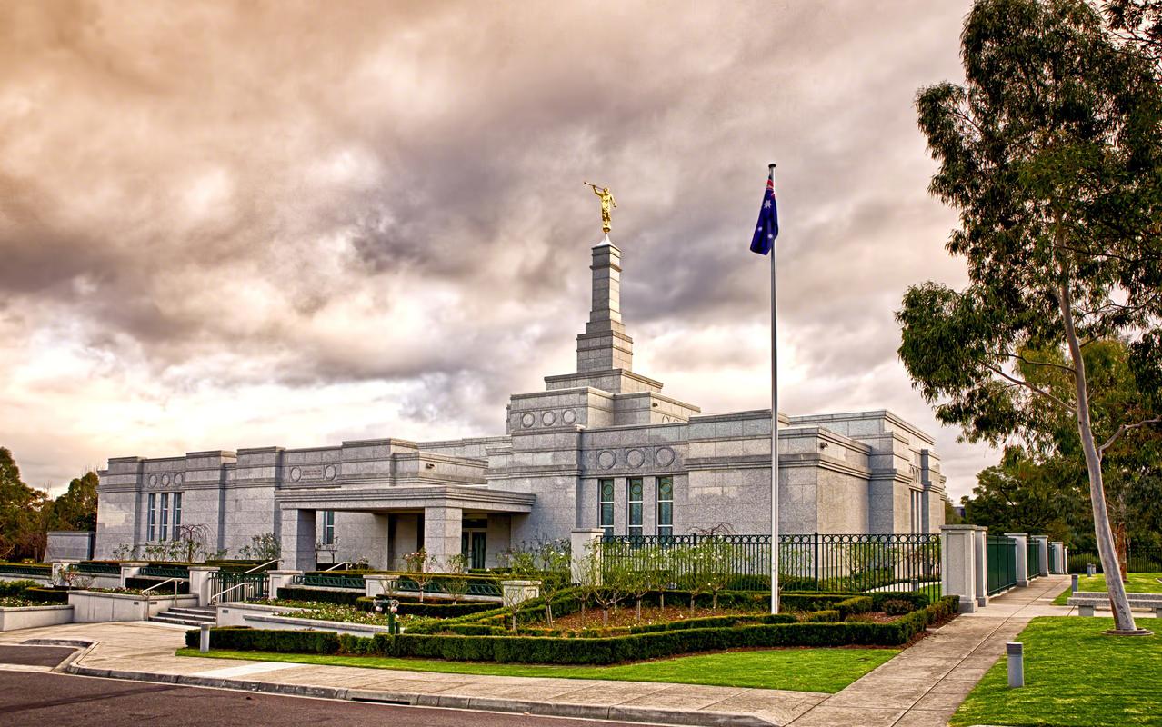 The Melbourne Australia Temple, a white building with a spire topped by a golden statue of an angel blowing a trumpet.