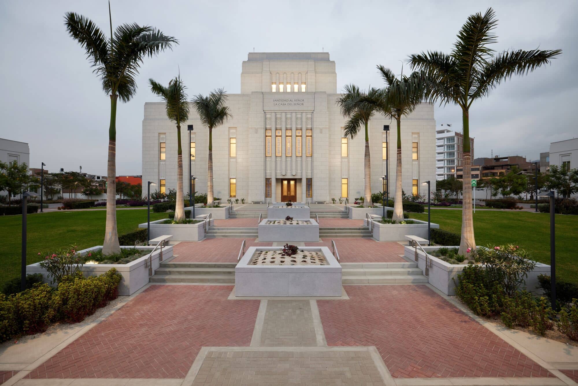 The exterior of the Lima Peru Los Olivos Temple, a light-gray building with long, rectangular windows and a flat-roofed tower.