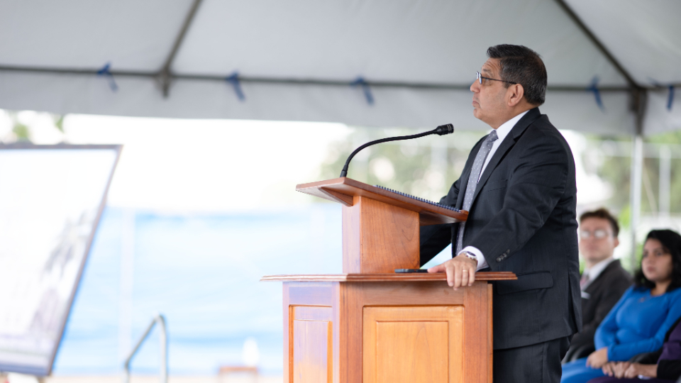 Elder Patricio M. Giuffra speaking from a pulpit at the Miraflores Guatemala City temple groundbreaking ceremony.