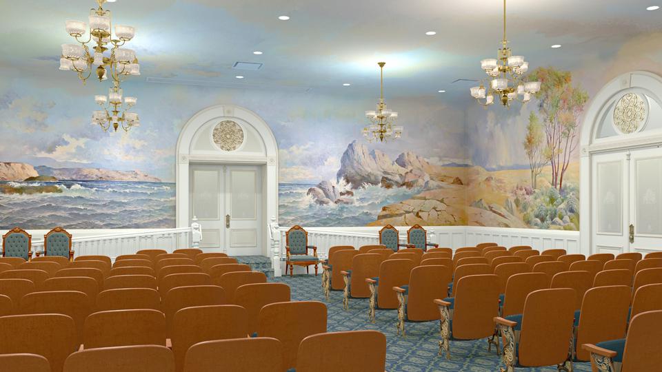 A room filled with chairs, with a mural of the ocean and large rocks near the shore all around the walls.