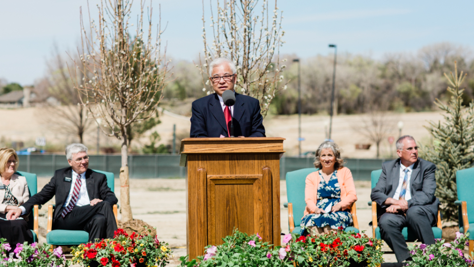 Elder Chi Hong (Sam) Wong speaks at the groundbreaking ceremony. He is accompanied by other members and Church leaders.